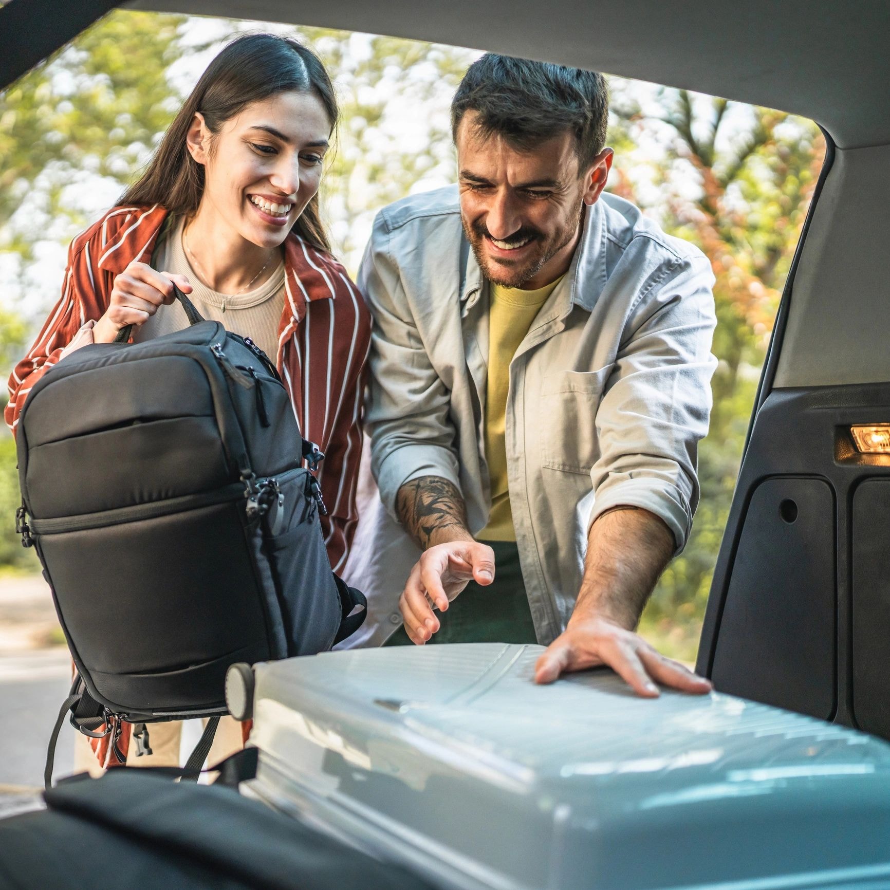 Passengers with luggage at car boot